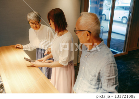 親子三人がホテルでチェックインするシーン 親子三人がホテルでチェックインするシーン 133721088