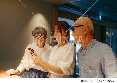 親子三人がホテルでチェックインするシーン 133721093