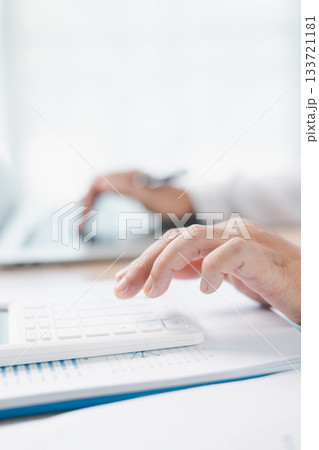 Close up of businesswoman using calculator for financial analysis and accounting on office desk with charts and reports. Concept of business planning, budget calculation and investment strategy. 133721181