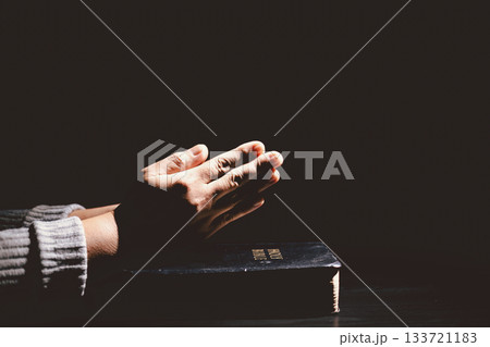 Hands clasped in prayer over the Holy Bible, symbolizing faith, devotion, Christianity, hope and spiritual strength through God Word, worship, meditation and encouragement. Hands clasped in prayer over the Holy Bible, symbolizing faith, devotion, Christianity, hope and spiritual strength through God Word, worship, meditation and encouragement. 133721183