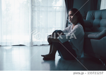 Tired depressed desperate tired girl sadly sitting on couch at home. Young woman is sitting on floor living room, feeling sad and depressed. Psychological problem. Depression and loneliness concept. Tired depressed desperate tired girl sadly sitting on couch at home. Young woman is sitting on floor living room, feeling sad and depressed. Psychological problem. Depression and loneliness concept. 133721237