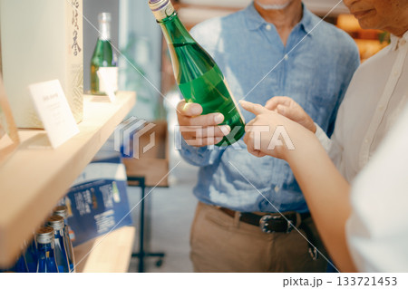 親子三人でお土産を選ぶホテルの売店シーン 133721453