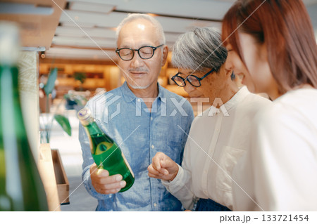 親子三人でお土産を選ぶホテルの売店シーン 133721454