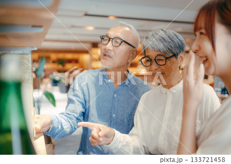 親子三人でお土産を選ぶホテルの売店シーン 親子三人でお土産を選ぶホテルの売店シーン 133721458