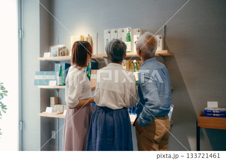 親子三人でお土産を選ぶホテルの売店シーン 133721461