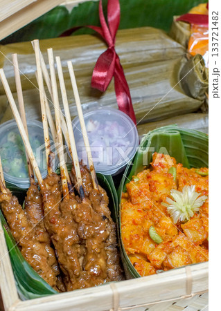 Indonesian lontong, chicken satay with peanut sauce, and spicy potato balado in bamboo hamper 133721482