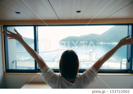 20代女性がホテル客室で絶景を眺めるシーン 133722002