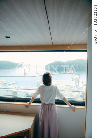 20代 女性がホテルの窓辺で景色を眺めるシーン 20代 女性がホテルの窓辺で景色を眺めるシーン 133722158