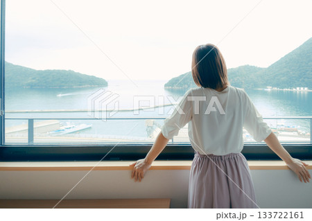 20代 女性がホテルの窓辺で景色を眺めるシーン 20代 女性がホテルの窓辺で景色を眺めるシーン 133722161