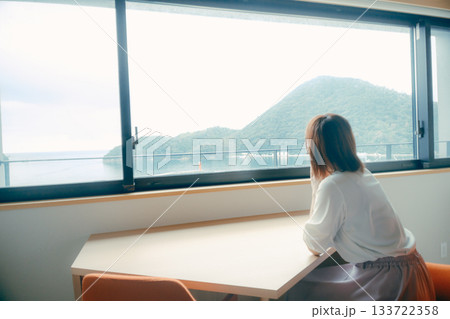 20代 女性がホテル客室で海と山の景色を眺めるシーン 133722358
