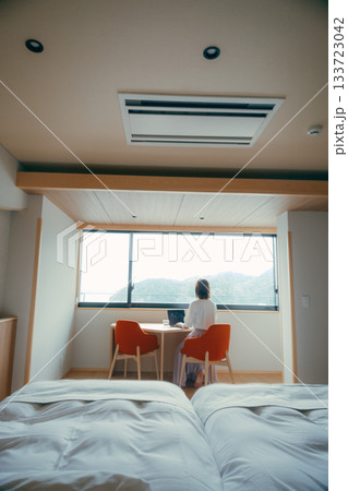 20代 女性がホテル客室でパソコン作業をするシーン 20代 女性がホテル客室でパソコン作業をするシーン 133723042