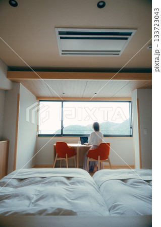 20代 女性がホテル客室でパソコン作業をするシーン 133723043