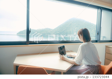 20代 女性がホテル客室でパソコン作業をするシーン 133723044