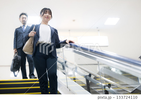 空港や駅のエスカレーターを降りるスーツ姿のキャリア女性のビジネス移動シーン 空港や駅のエスカレーターを降りるスーツ姿のキャリア女性のビジネス移動シーン 133724110