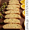 Soft focus image of biscotti cookies, lined by pistachio nuts and orange slices, classic holiday flavors 133724793