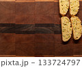 Four orange and pistachio biscotti cookies placed at the upper right of the image, with a wood background and copy space 133724797
