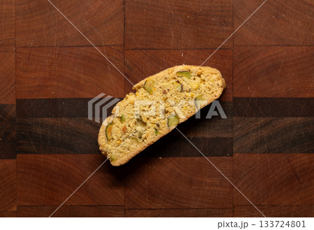 Home baked pistachio and orange biscotti on a wooden cutting board 133724801