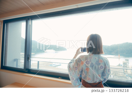 浴衣姿の20代女性がホテルの窓から景色を眺めるシーン 浴衣姿の20代女性がホテルの窓から景色を眺めるシーン 133726218