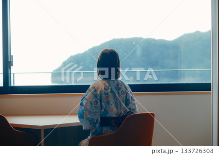浴衣姿の20代女性が海を眺めながら静かに佇むシーン 133726308