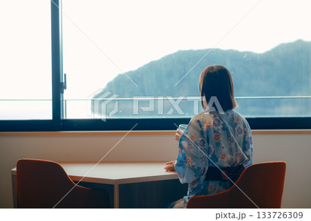 浴衣姿の20代女性が海を眺めながら静かに佇むシーン 133726309