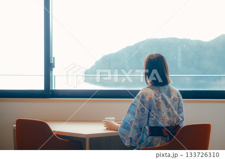 浴衣姿の20代女性が海を眺めながら静かに佇むシーン 133726310