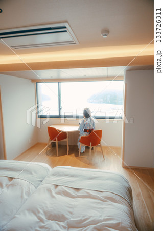 浴衣姿の20代女性が海を眺めながら静かに佇むシーン 133726311