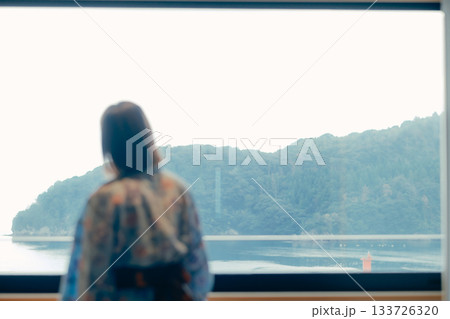 浴衣姿の20代女性が海を眺めながら静かに佇むシーン 133726320