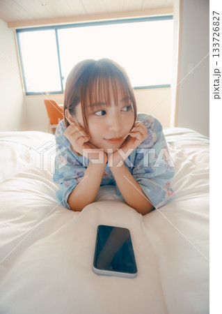 浴衣姿の女性がベッドでうつ伏せにくつろぐシーン 浴衣姿の女性がベッドでうつ伏せにくつろぐシーン 133726827