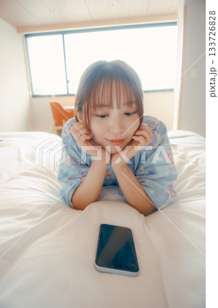 浴衣姿の女性がベッドでうつ伏せにくつろぐシーン 浴衣姿の女性がベッドでうつ伏せにくつろぐシーン 133726828