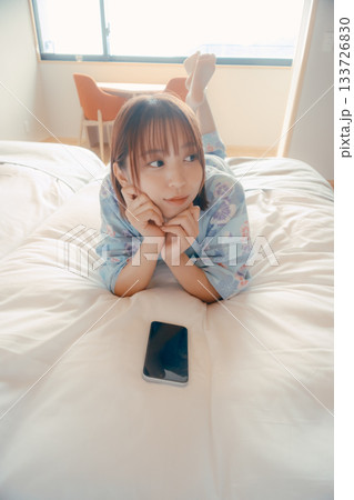 浴衣姿の女性がベッドでうつ伏せにくつろぐシーン 浴衣姿の女性がベッドでうつ伏せにくつろぐシーン 133726830
