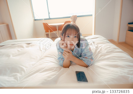 浴衣姿の女性がベッドでうつ伏せにくつろぐシーン 浴衣姿の女性がベッドでうつ伏せにくつろぐシーン 133726835