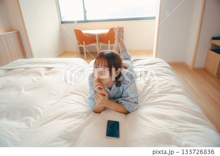 浴衣姿の女性がベッドでうつ伏せにくつろぐシーン 浴衣姿の女性がベッドでうつ伏せにくつろぐシーン 133726836