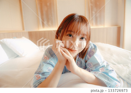 浴衣姿の女性がベッドでくつろぐシーン 133726973
