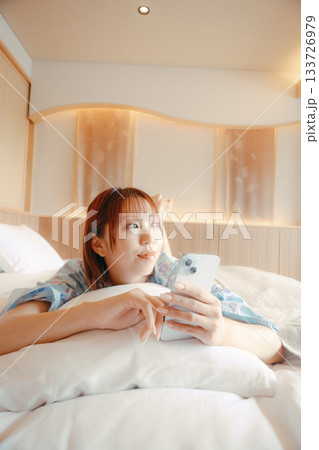 浴衣姿の女性がベッドでくつろぐシーン 133726979