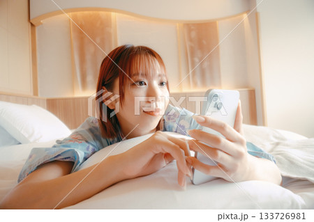 浴衣姿の女性がベッドでくつろぐシーン 133726981