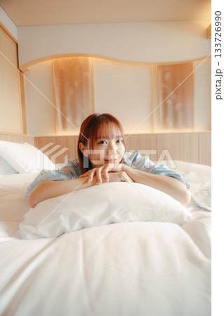 浴衣姿の女性がベッドでくつろぐシーン 133726990