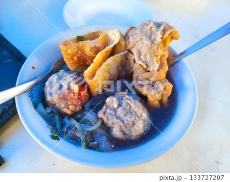 Close-up of Bakso, Indonesian meatball soup, featuring large meatballs, siomay, and noodles in savory broth. Close-up of Bakso, Indonesian meatball soup, featuring large meatballs, siomay, and noodles in savory broth. 133727207