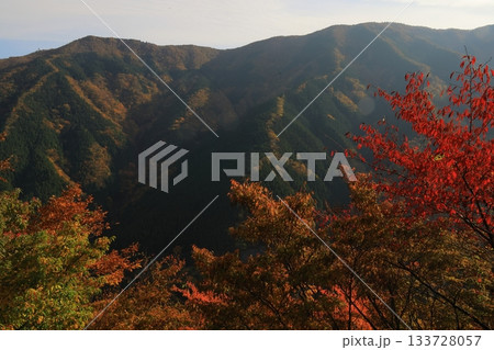 燃えるような手前の紅葉と雄大なナメゴ谷の山肌 133728057