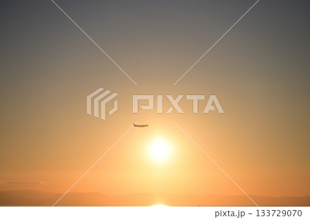 夕暮れの伊勢湾上空を飛ぶ飛行機 133729070