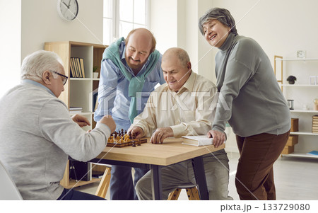 Group of happy diverse senior people playing chess in nursing home sitting at the table. Group of happy diverse senior people playing chess in nursing home sitting at the table. 133729080