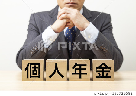 「個人年金」と書かれたブロックとビジネスマン 「個人年金」と書かれたブロックとビジネスマン 133729582