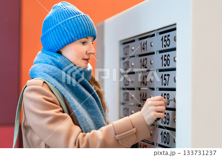 Woman opens a mailbox 133731237