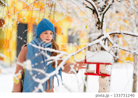 Woman stands near a feeding trough 133731240