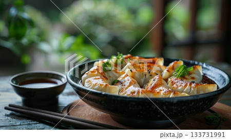 A Delicious and Appetizing Plate of Golden Brown Dumplings Beautifully Garnished with Fresh Chives and Sauce 133731991