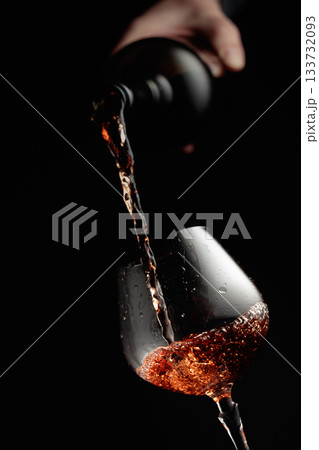 Pouring brandy in a glass goblet. 133732093
