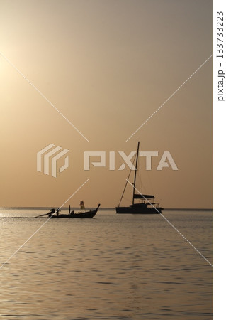 Sunset on tropical island sea beach Thailand, calm ocean sunrise landscape, fisherman boat, ship silhouette, golden sun glow reflection, colorful sky clouds, summer holidays, vacation, travel Sunset on tropical island sea beach Thailand, calm ocean sunrise landscape, fisherman boat, ship silhouette, golden sun glow reflection, colorful sky clouds, summer holidays, vacation, travel 133733223