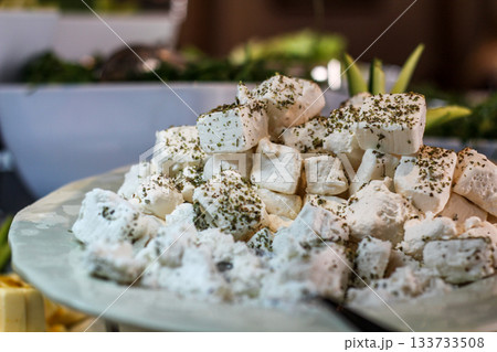 Greek feta cubes with herbs and spices, diced soft cheese isolated on white background with clipping path 133733508