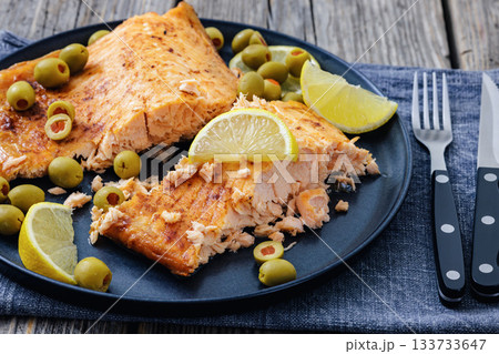 roasted salmon fillet on plate with green olives roasted salmon fillet on plate with green olives 133733647