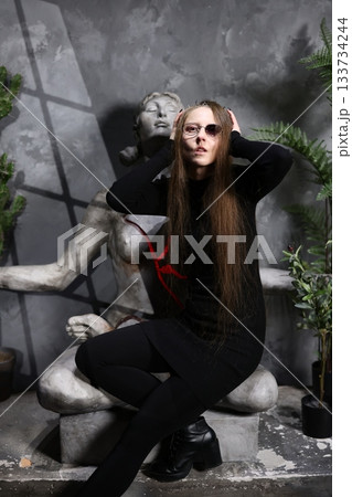 Female figure illuminated beside fractured artwork and greenery Female figure illuminated beside fractured artwork and greenery 133734244