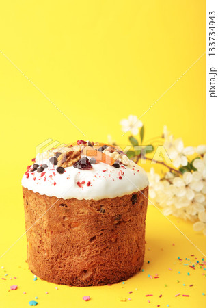 Traditional easter cakes with colorful sprinkles, with eggs and spring flowers on yellow background. Traditional easter cakes with colorful sprinkles, with eggs and spring flowers on yellow background. 133734943